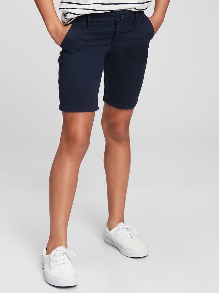 Image 1 of 4, Same dress code. All new fits. Inspired by their weekend favorites — remixed for school days., Made with 20% organically grown cotton. Organic cotton is better for people and the environment because it's grown without the use of harmful synthetic pesticides and fertilizers., Soft, stretch weave uniform bermuda shorts., Button at center front (sizes 4-8 have a hook & bar closure beneath faux snap for easy on and off), zip fly., Front slant pockets, back welt pockets., These shorts were made in a factory that runs the Gap Inc. P.A.C.E. (Personal Advancement & Career Enhancement) program. P.A.C.E. is our educational program that helps the women who make our clothes build the skills, knowledge, confidence & resilience needed to advance in work & life. Learn more at gap.com/pace, Product #710539