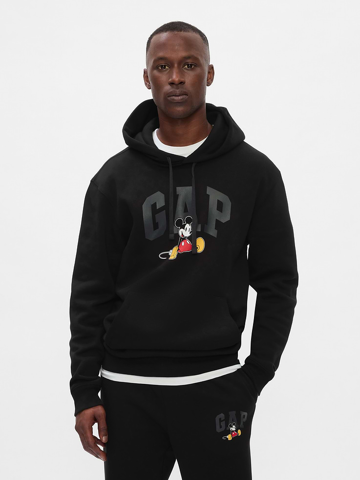 Image 1 of 4, A very special collaboration between Gap and Disney— two timeless, iconic American brands— led us to create a collection that celebrates Mickey Mouse and Minnie Mouse., Soft, comfy fleece., Dropped shoulder, long sleeves with banded cuffs., Drawcord ties at hood., Gap logo with Mickey Mouse graphic at front., Kanga pocket., Banded hem., This product was made in a factory that invests in gender equity and women’s empowerment through RISE. Learn more at, Product #626285