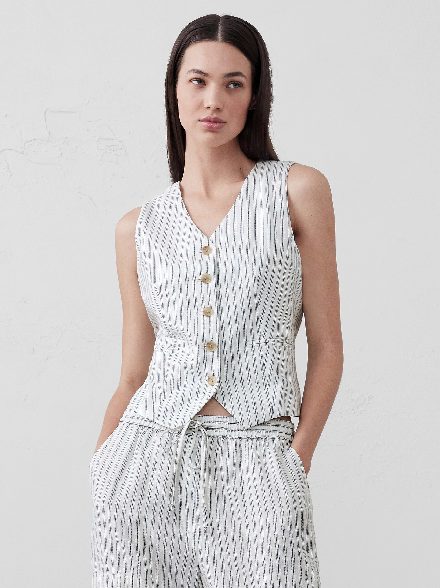 Image 1 of 4, LINEN-BLEND: This light and breathable fabric is a must for those warm days and styles effortlessly for all occasions., V-neck. Sleeveless., Button front closure., Welt front pockets., Adjustable belt tab on back for a more fitted look., Straight hem with cut away front., Fully lined., Made exclusively for Banana Republic Factory., Product #696056