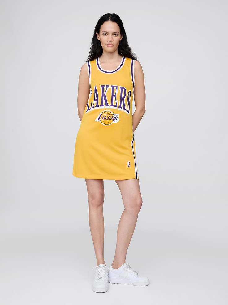 Image 1 of 5, We teamed up with the NBA to celebrate the league’s 75+ year history. Pairing iconic team logos with Gap classics. Made to celebrate the game, for the people who love it most., Soft recycled knit jersey mini dress., Scoop neck, racerback., Sleeveless., Striped rib trim at neckline, armholes, and side seams., Los Angeles Lakers logo at front., NBA label at thigh., This jersey dress is made with 100% recycled polyester. Compared to virgin materials, using recycled materials helps to reduce resource use and waste., Product #799774