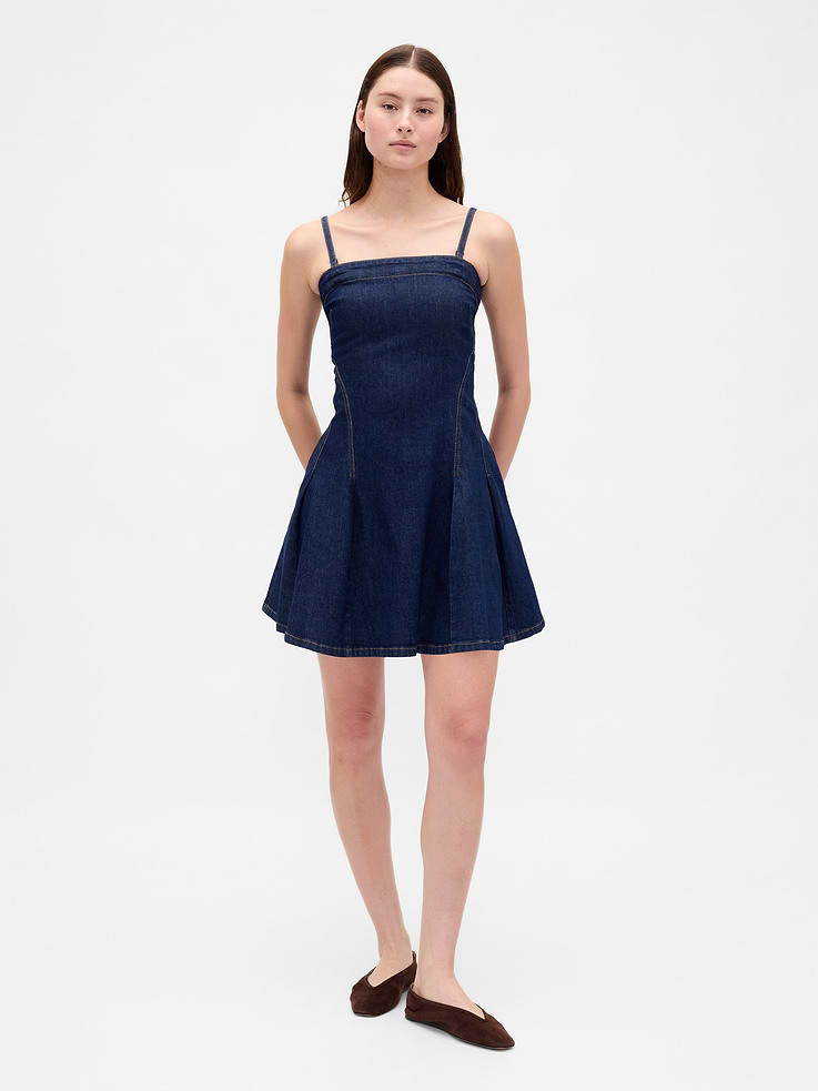Image 1 of 7, Authentic low-stretch denim mini dress., Square neck., Adjustable, removable spaghetti straps. Can be worn strapless., Exposed zipper closure at back., Seamed bodice., Side welt pockets., Pleating detail at skirt., Dark wash., Responsibly Made: This denim dress is part of our water-saving Washwell program. Compared with conventional wash methods, Washwell uses at least 20% less water., More Sustainable Cotton: Made with 5% recycled cotton. Compared to virgin materials, using recycled materials helps reduce resource use and waste., This product was made in a factory that invests in gender equality and women’s empowerment. Through RISE (Reimagining Industry to Support Equality) and Gap Inc.’s program P.A.C.E. (Personal Advancement & Career Enhancement), we support people who make our clothes to build the skills, knowledge, confidence, and resilience needed to advance in work and life. Learn more here ., Product #788742