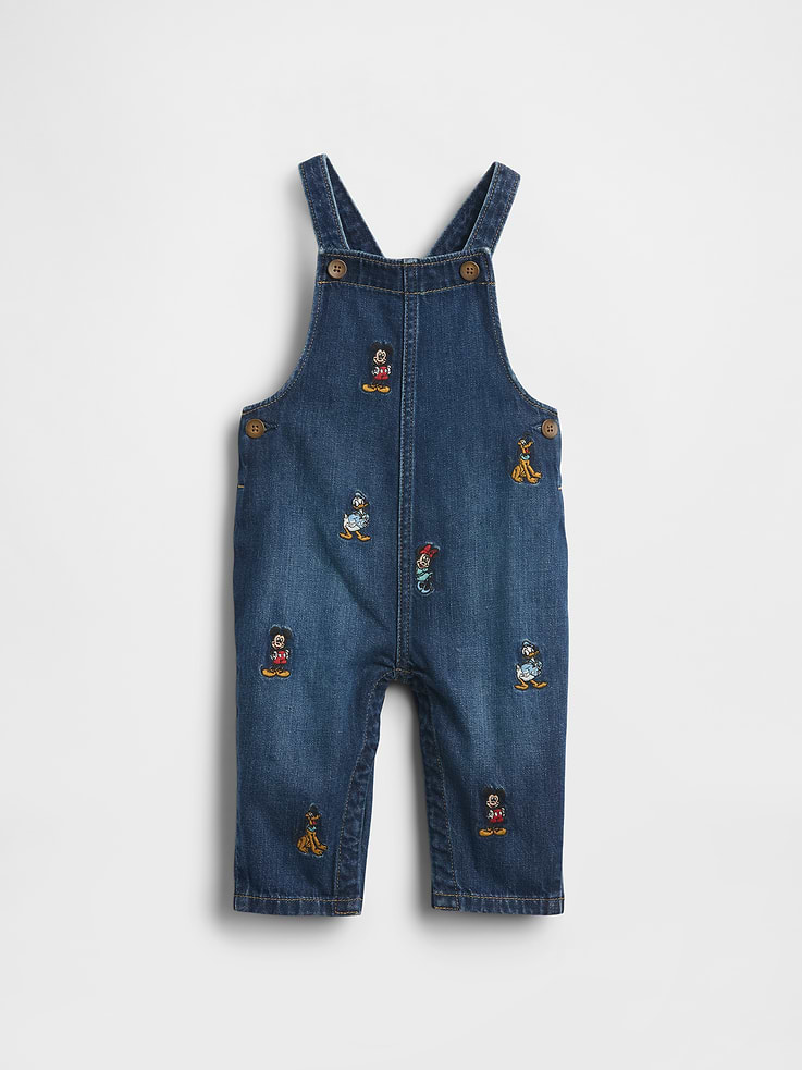 Image 1 of 5, Characters for your little characters. Making every day more special., Authentic non-stretch denim overalls., Square neck., Adjustable crossback tank straps with front button closure., Buttons at sides., Allover Disney Mickey Mouse & Friends embroidered character graphics., Responsibly Made: This pair of denim overalls is part of our water-saving Washwell program. Compared with conventional wash methods, Washwell uses at least 20% less water., More Sustainable Cotton: Made with 5% recycled cotton. Compared to virgin materials, using recycled materials helps reduce resource use and waste., This product was made in a factory that invests in gender equity and women’s empowerment through RISE. Learn more at gapinc.com/equity ., Product #816521