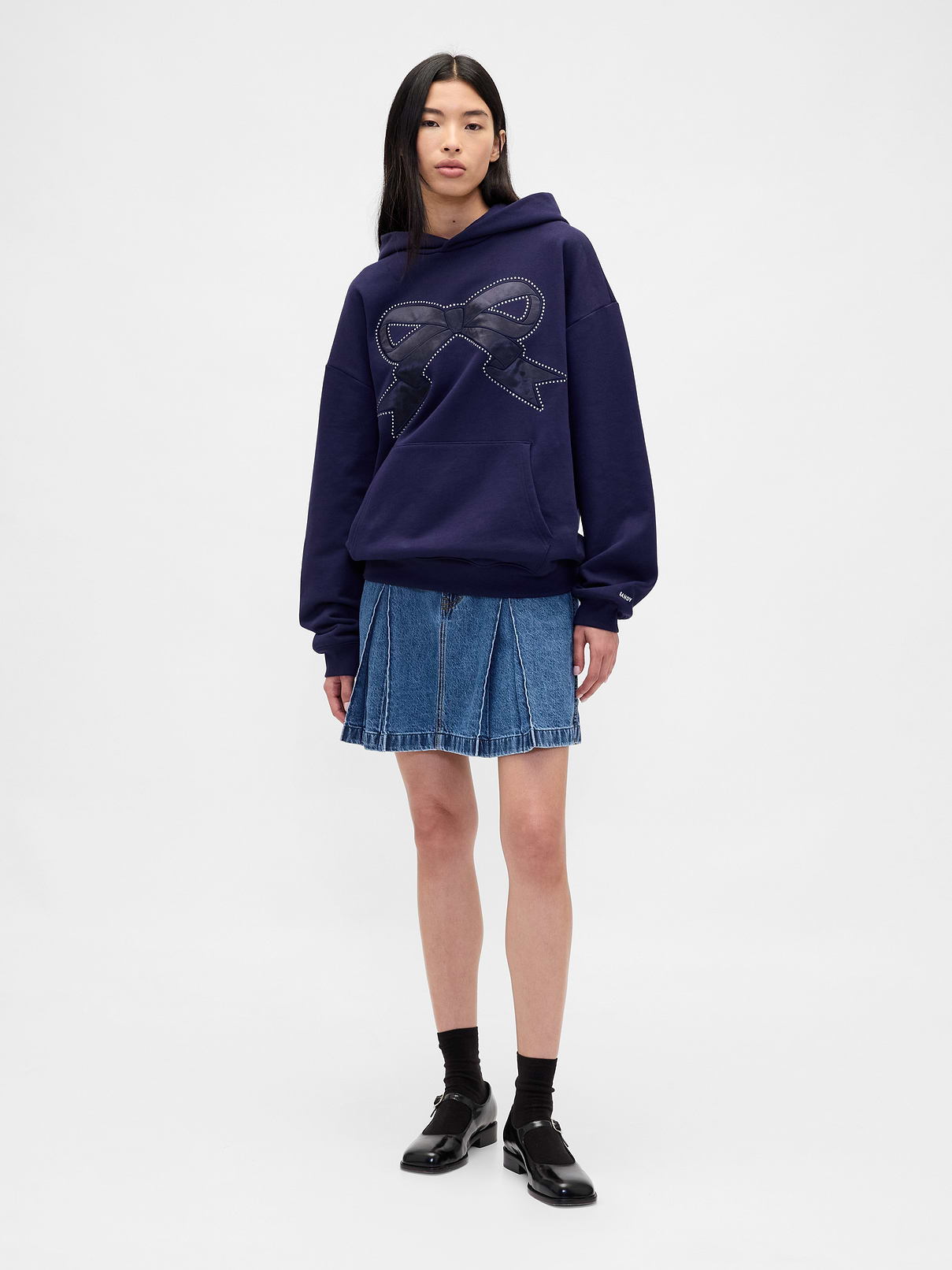 Image 1 of 6, Sandy Liang is designer born and raised in NYC. Inspired by nostalgia, she creates cult-favorite pieces influenced by childhood. Our collection draws from her memories of growing up with Gap. Archival hints. Playful details for adults. Elevated designs for kids. A celebration of modern girlhood only Gap × Sandy Liang could make., Authentic, non-stretch denim mini skirt., Button closure, zip fly., Pleated skirt., Responsibly Made: This denim skirt is part of our water-saving Washwell program. Compared with conventional wash methods, Washwell uses at least 20% less water., More Sustainable Cotton: Made with 100% regenerative cotton which is grown using holistic agricultural practices that improve soil health, climate resilience, water retention, and local biodiversity., Product #853517
