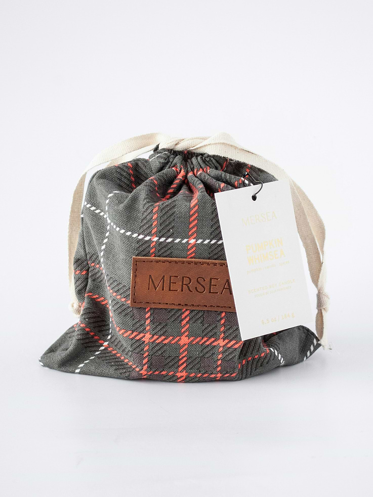 Image 1 of 2, Pumpkin, Vanilla, Spices., A warm welcome back to a favorite seasonal scent, Pumpkin Whimsea., This warm and inviting fragrance will make you want to stay in fall forever., The rich and earthy scent of pumpkin is sweetened with notes of vanilla and balanced out with a touch of spice., This is the subtle, warming autumn scent you’ve been waiting for., The ever-popular Sandbag Candle, now dressed in a charming plaid bag., Our classic 6.5-ounce candles are hand-poured into sheer white glass vessels that can be beautifully repurposed long after the flame fades., Thoughtfully packaged with matches in a reusable plaid bag—perfect for stashing keepsakes or seasonal treasures—this candle is finished with our signature uplifting gift tag, making it a perfect gift for any occasion.