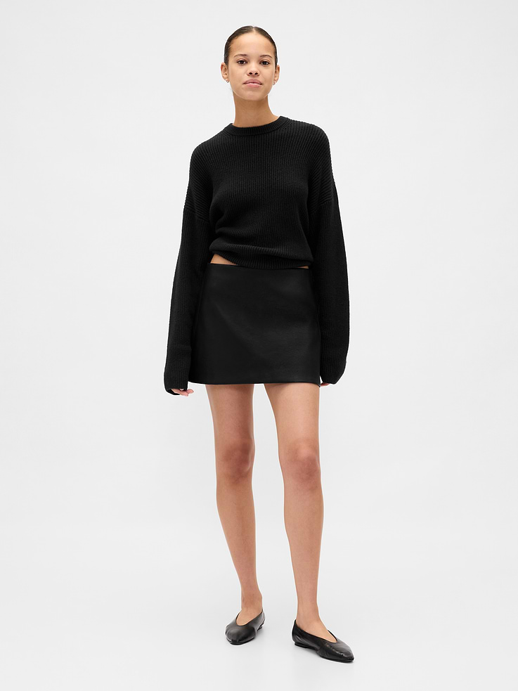 Image 1 of 4, Smooth vegan leather mini skort., Zipper with hook-and-eye closure at side seam., Inner knit shorts., Skirt made with 100% recycled polyester. Compared to virgin materials, using recycled materials helps reduce resource use and waste., This product was made in a factory that invests in gender equity and women’s empowerment through RISE. Learn more at gapinc.com/equity., Product #842721