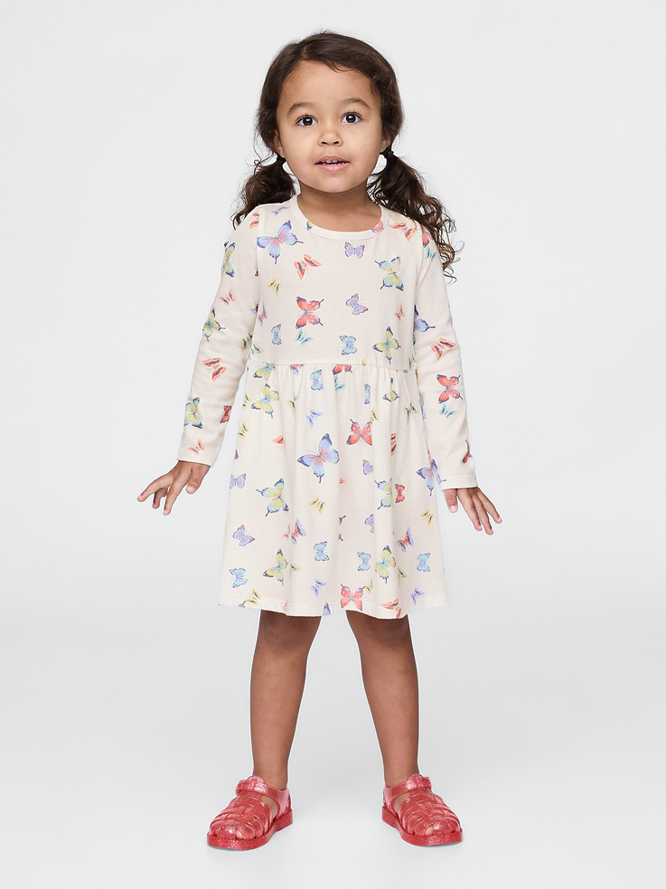 Image 1 of 3, Our favorite mix-and-match essentials go from tummy time to playtime in no time. All made with soft cotton in playful prints and bright colors., Soft, stretch jersey skater dress., Crewneck., Long sleeves., Embroidered Brannan Bear at chest., Front slant pockets., Allover butterfly print., 100% of the cotton in this dress is verified by the U.S. Cotton Trust Protocol, a program which works with farms committed to improving their environmental footprint by minimizing water usage and improving soil diversity (Claim No. B6AFDACC-10117)., This product was made in a factory that invests in gender equality and women’s empowerment. Through RISE (Reimagining Industry to Support Equality) and Gap Inc.’s program P.A.C.E. (Personal Advancement & Career Enhancement), we support people who make our clothes to build the skills, knowledge, confidence, and resilience needed to advance in work and life. Learn more here ., Product #736174