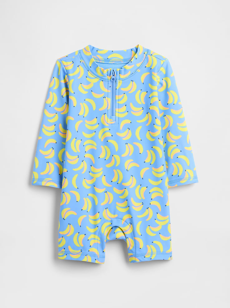 Image 1 of 3, Stretch knit., Long sleeves., Round neckline, quarter-zip front., Hidden snaps at inseam for easy dressing and diapering., Select styles have allover print., UPF 50+: Excellent UV Protection., Accords with ASTM Standard D6603., This product was made in a factory that invests in gender equity and women’s empowerment through RISE. Learn more at gapinc.com/equity., Product #1174081
