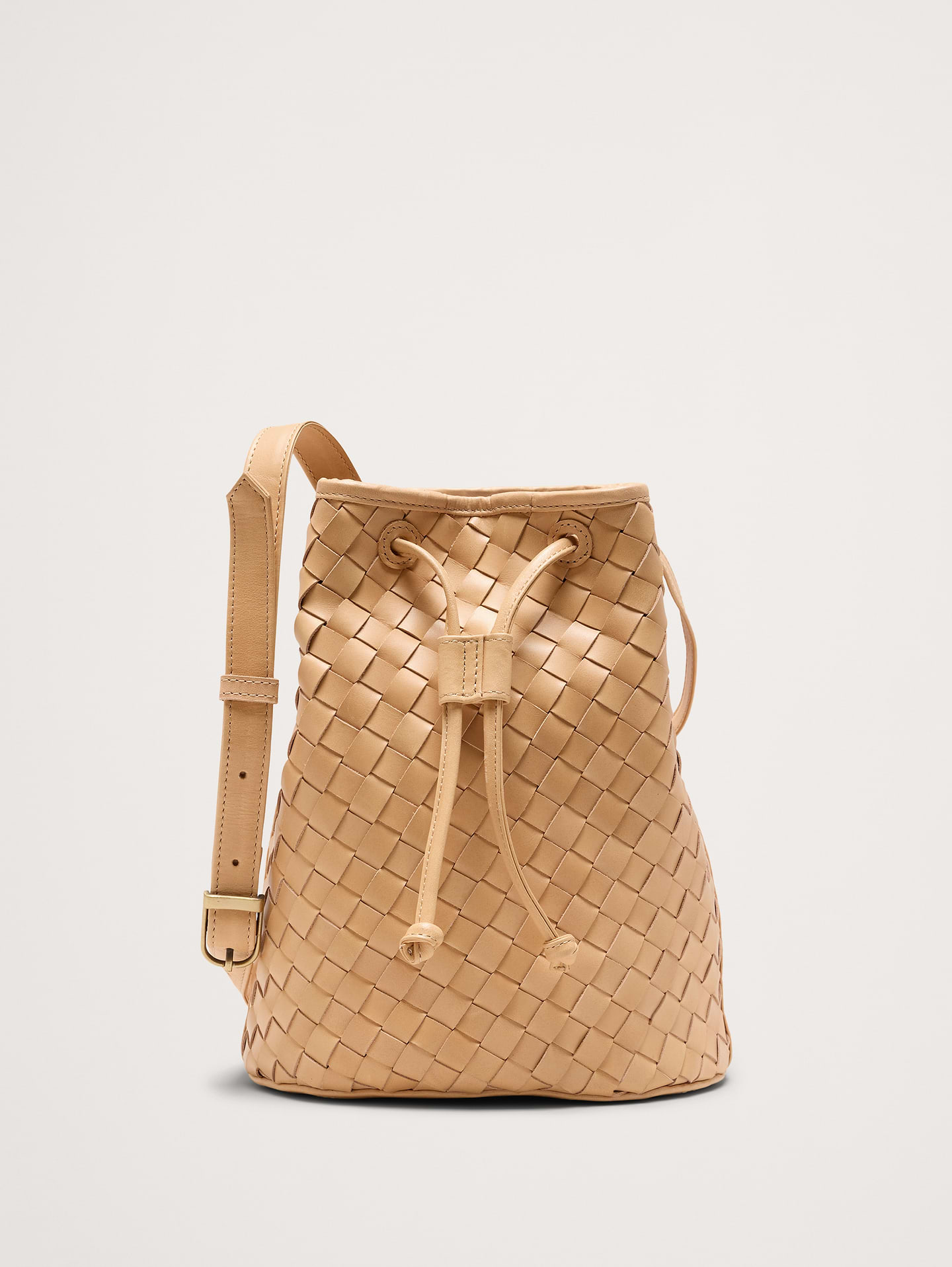 Image 1 of 6, Bembien's vintage-inspired bucket bag in handwoven carré leather. Feature a long, adjustable shoulder strap and drawstring closure., Bembien: Beautiful, thoughtfully made accessories. Each Bembien piece is made by hand in small, considered batches using techniques passed down through generations., Drawstring closure., Cotton lining., Adjustable strap., Product #872272