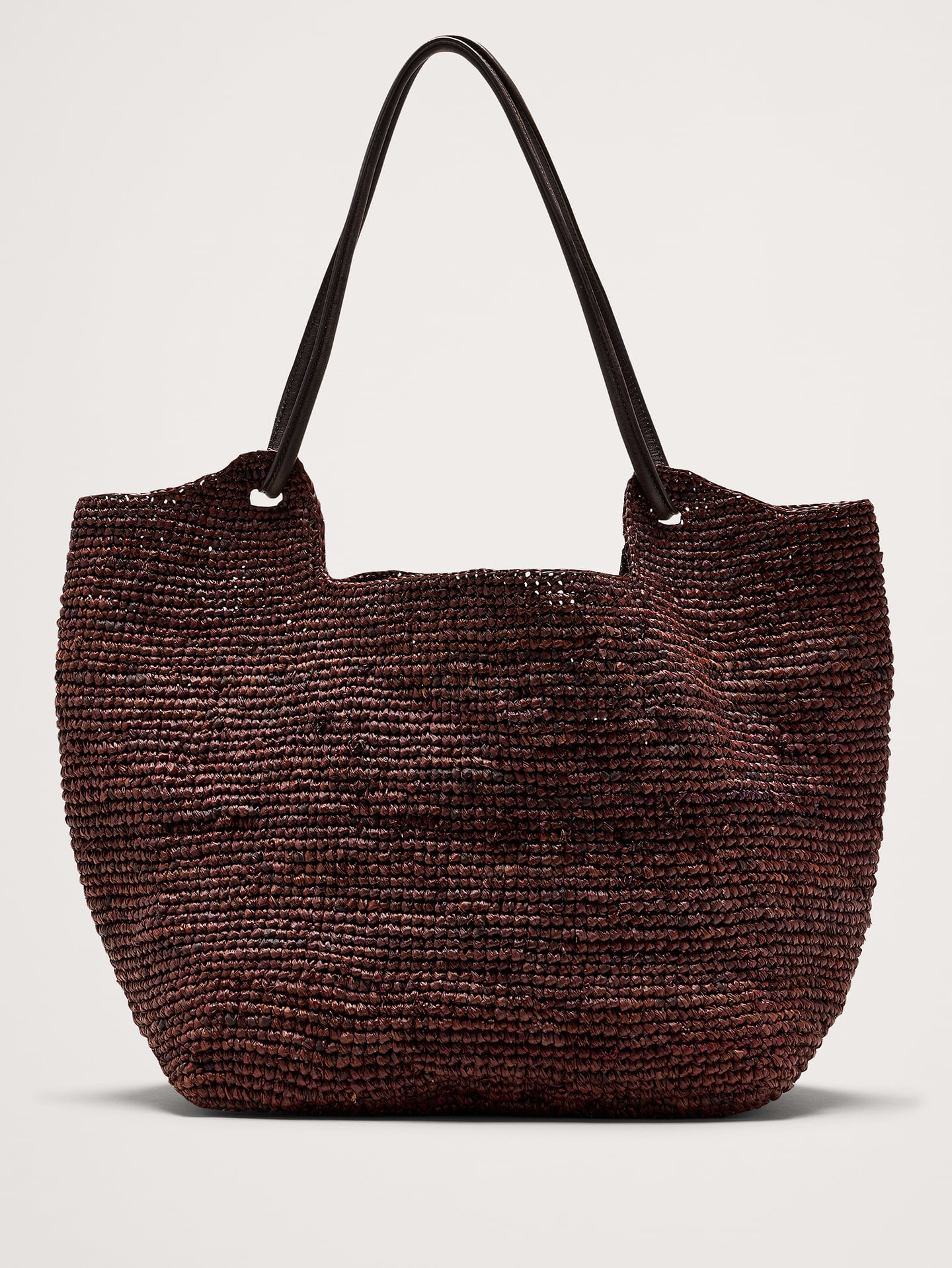 Image 1 of 6, A timeless tote silhouette in oversized proportions, woven by hand from natural raffia with sturdy leather shoulder straps., Bembien: Beautiful, thoughtfully made accessories. Each Bembien piece is made by hand in small, considered batches using techniques passed down through generations., Leather straps., Handwoven raffia., Interior pocket., Product #899879