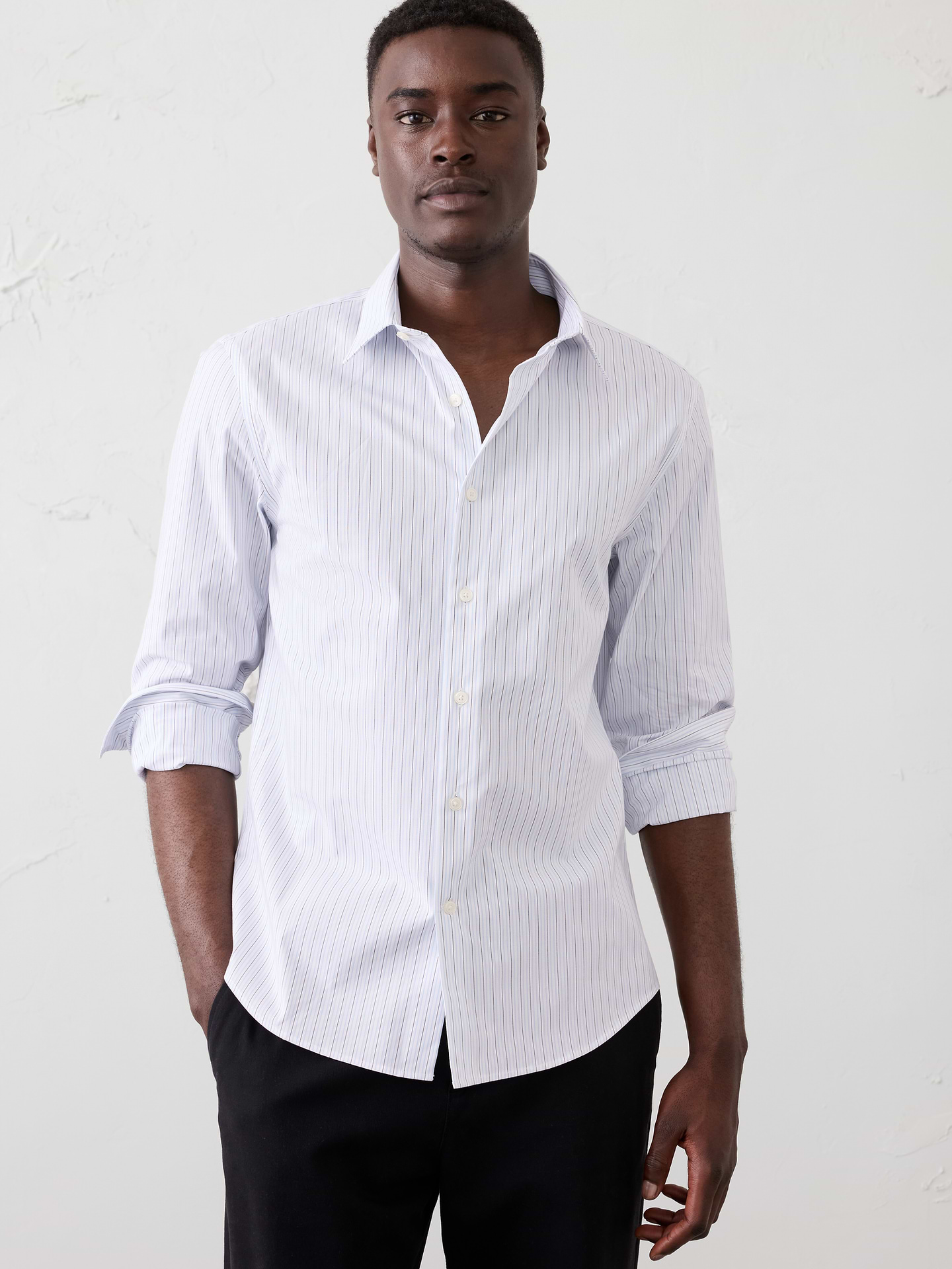 Image 1 of 8, UNTUCKED: Designed with a shorter hemline to hit right at the hips., WRINKLE RESISTANT: No need to iron, this soft, dress shirt is specially engineered to resist wrinkles so it stays looking crisp and pulled-together., Spread collar. Long sleeves with adjustable double-button barrel cuffs and button vents., Clean front., Shirttail hem., Made exclusively for Banana Republic Factory., Product #801207