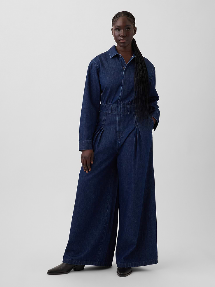 Image 1 of 8, Jimmy Latouche is a scientist of textiles. His innovative designs blend fabric chemistry, classic tailoring & bold colors. He’s a barrier-breaking suit maker with an aesthetic of his own making., Authentic, non-stretch denim jumpsuit., Spread collar., Long sleeves with button cuffs., Hidden half-zip closure., Elasticized waist., Front slant pockets., Pleating at wide leg., Responsibly Made: This denim jumpsuit is part of our water-saving Washwell program. Compared with conventional wash methods, Washwell uses at least 20% less water., More Sustainable Cotton: Made with 5% recycled cotton. Compared to virgin materials, using recycled materials helps reduce resource use and waste., This product was made in a factory that invests in gender equity and women’s empowerment through RISE. Learn more at gapinc.com/equity ., Product #894740