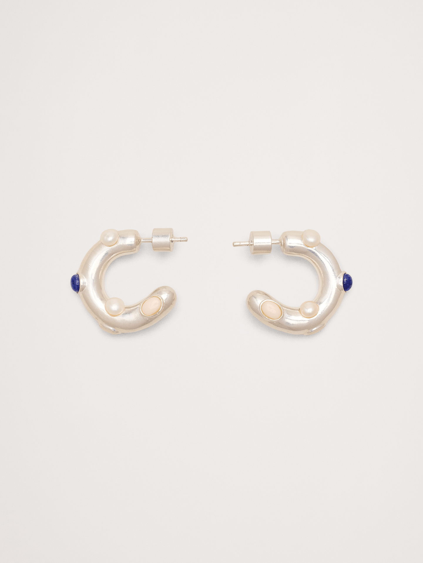 Image 1 de 1, Un trio de pierres précieuses accentue la façade sculpturale et ondulée de ces créoles, offertes en or 14 carats ou en laiton plaqué argent 999 au choix., Laiton plaqué or 14 carats ou argent 999., Fermoir à tige., Perles d'eau douce, lapis-lazuli et pierres de résine., Produit #894354