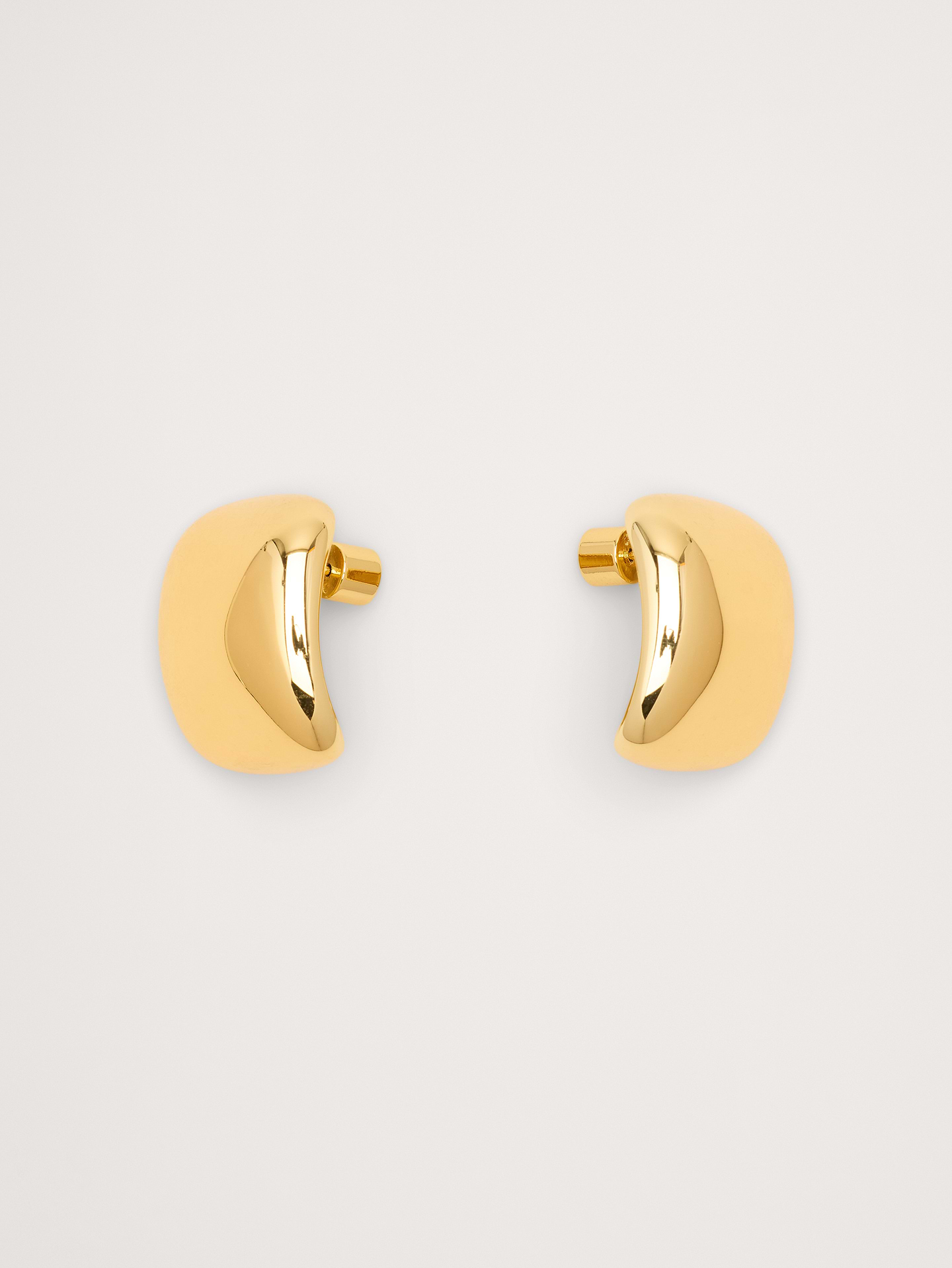 Image 1 of 5, Sleek and sculptural, these post-back earrings have a gently curved shape reminiscent of squared pebbles. Crafted in your choice of 14k-gold or rhodium plated brass., Martha Calvo: Miami-based jewelry brand known for bold chains, freshwater pearls, and playful, high-impact pieces made by hand. Designed to be mixed, matched, and enjoyed., 14k-gold or rhodium plated brass., Post backs., Product #899767