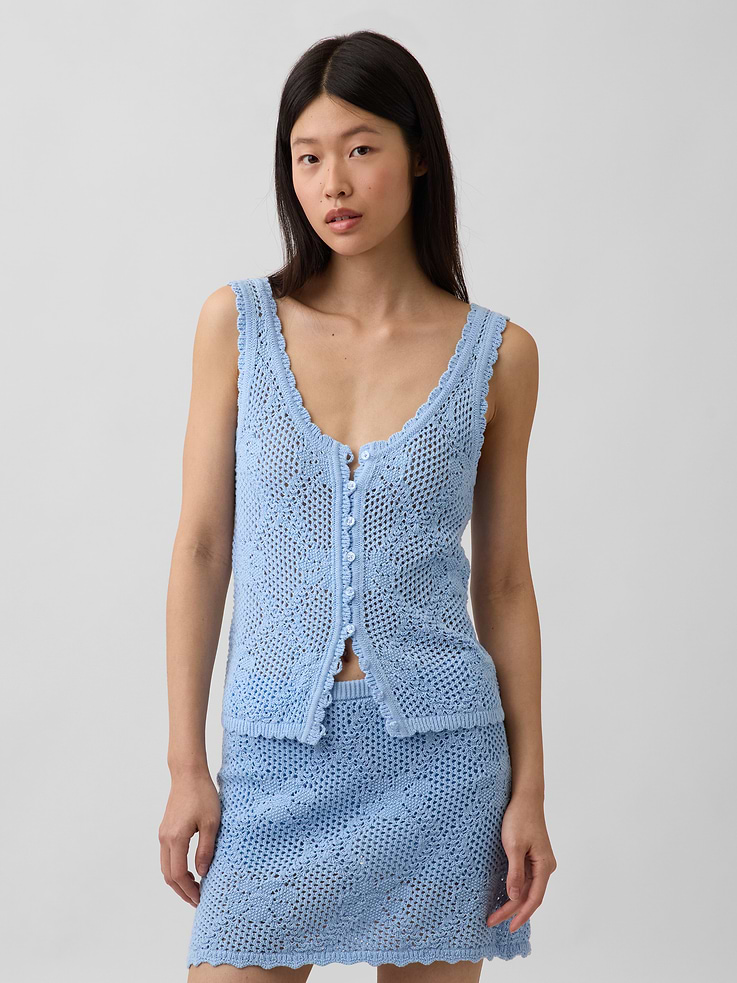 Image 1 of 5, Soft pointelle knit cotton sweater tank top. In a slightly cropped length., V-neck., Sleeveless., Allover floral pattern., Scalloped rib hem., This product was made in a factory that invests in gender equity and women’s empowerment through RISE. Learn more at gapinc.com/equity ., Product #897008