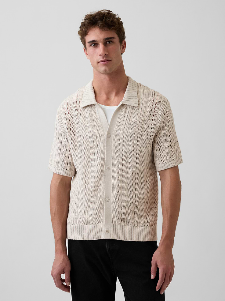 Image 1 of 5, Soft crochet knit cotton button sweater shirt. In an oversized fit., Spread collar, button front., Short sleeves., Herringbone pattern., Ribbed hem., This product was made in a factory that invests in gender equity and women’s empowerment through RISE. Learn more at gapinc.com/equity ., Product #869799