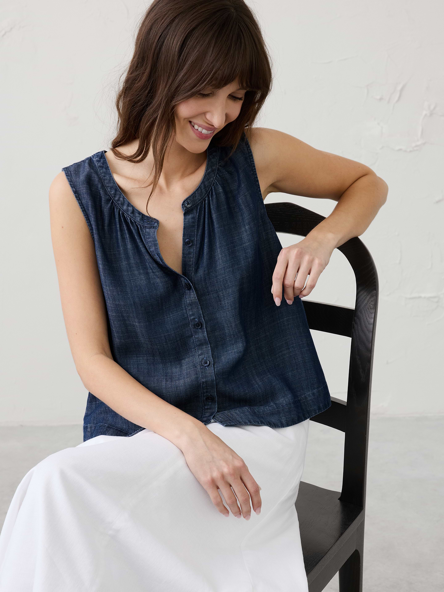 Image 1 of 6, Our sleeveless chambray button‑down features a classic crew neckline accented by delicate shirring. The result is a relaxed yet polished silhouette—perfect for casual wear or easy layering., Slim banded crew neck. Sleeveless., Button front closure., Soft shirring from the front and back neckline., Subtle flare toward straight hem., Made exclusively for Banana Republic Factory., Product #1175132