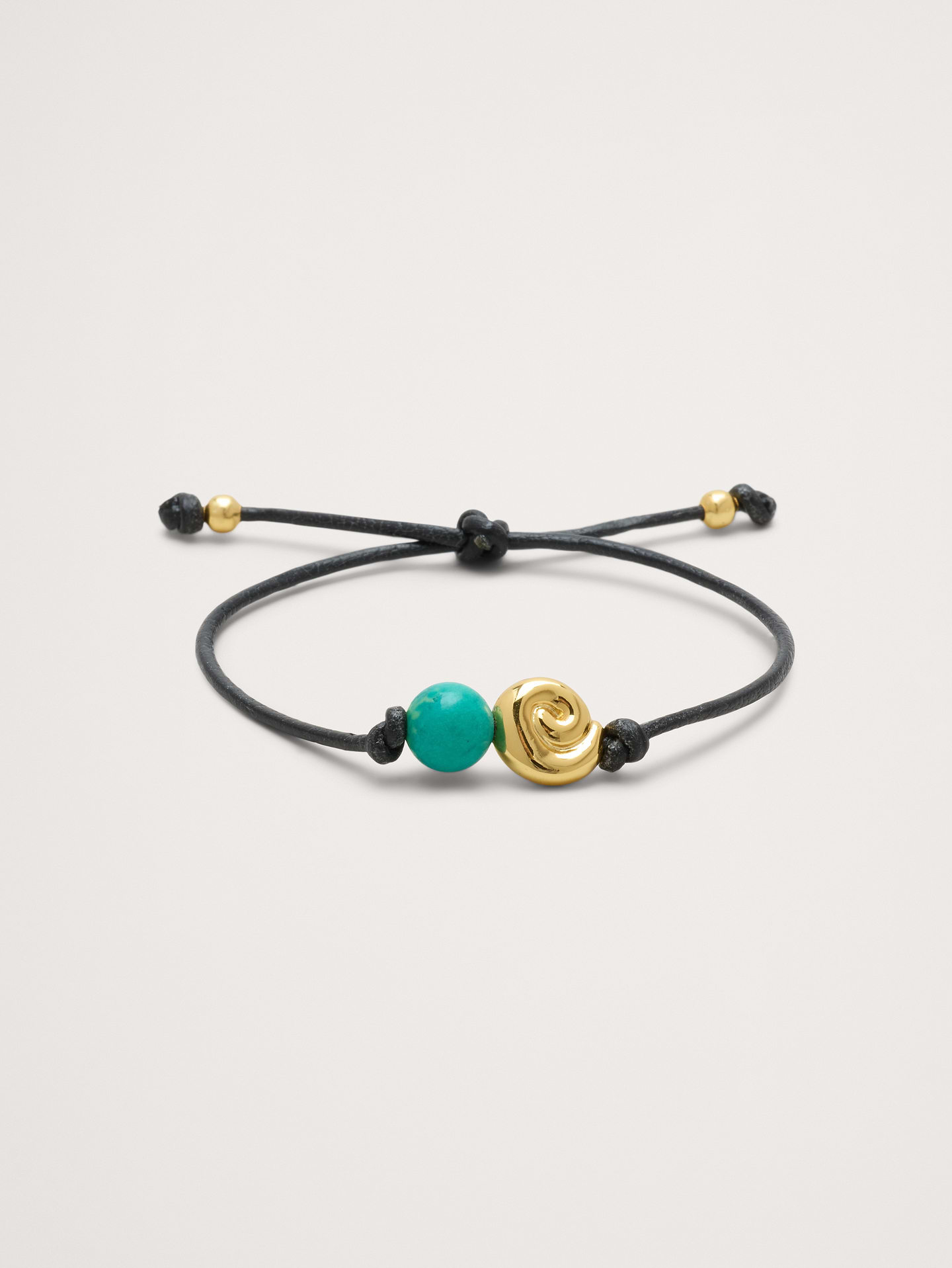 Image 1 of 3, Turquoise stone beads and a shell-inspired spiral sphere suspended from a simple, leather cord bracelet., Adjustable slider closure., Product #906916
