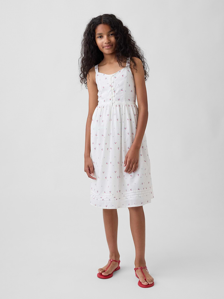 Image 1 of 4, Soft cotton midi tank dress., V-neck with front loop button placket., Tank straps., Elasticized back waist., Pleating at bottom., Certain styles have eyelet embroidery detailing at bodice or an allover floral print., This product was made in a factory that invests in gender equity and women’s empowerment through RISE. Learn more at gapinc.com/equity ., Product #898869