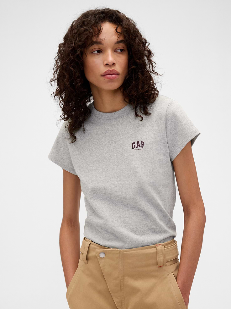 Image 1 of 5, Known for her timeless silhouettes and immaculate tailoring, Victoria Beckham's singular take on style is rooted in a sense of sophisticated ease. Through her lens, our icons take on a new form. Feminine. Powerful. Artistic. Grounded in elevated staples — and denim. The unexpected meeting of Victoria Beckham and Gap., Soft cotton T-shirt. In a slightly cropped fit., Crewneck., Short sleeves., Gap x Victoria Beckham logo at chest., Made with 100% organically grown cotton which is grown without the use of synthetic pesticides and fertilizers., This product was made in a factory that invests in gender equity and women’s empowerment through RISE. Learn more at gapinc.com/equity ., Product #902742