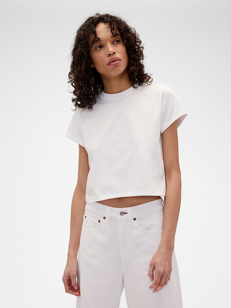 Image 1 of 2, Known for her timeless silhouettes and immaculate tailoring, Victoria Beckham's singular take on style is rooted in a sense of sophisticated ease. Through her lens, our icons take on a new form. Feminine. Powerful. Artistic. Grounded in elevated staples — and denim. The unexpected meeting of Victoria Beckham and Gap., Soft cotton T-shirt. In a cropped fit., Crewneck., Short sleeves., Gap x Victoria Beckham logo at back., Made with 100% organically grown cotton which is grown without the use of synthetic pesticides and fertilizers., This product was made in a factory that invests in gender equity and women’s empowerment through RISE. Learn more at gapinc.com/equity ., Product #903390