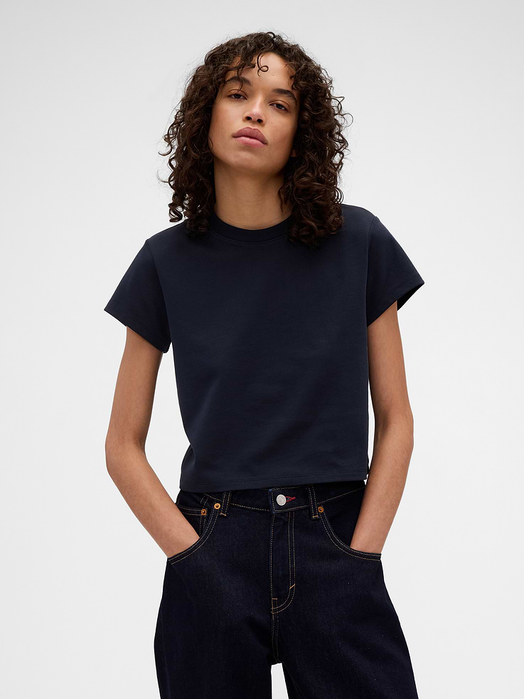Image 1 of 2, Known for her timeless silhouettes and immaculate tailoring, Victoria Beckham's singular take on style is rooted in a sense of sophisticated ease. Through her lens, our icons take on a new form. Feminine. Powerful. Artistic. Grounded in elevated staples — and denim. The unexpected meeting of Victoria Beckham and Gap., Soft cotton T-shirt. In a cropped fit., Crewneck., Short sleeves., Gap x Victoria Beckham logo at back., Made with 100% organically grown cotton which is grown without the use of synthetic pesticides and fertilizers., This product was made in a factory that invests in gender equity and women’s empowerment through RISE. Learn more at gapinc.com/equity ., Product #903390