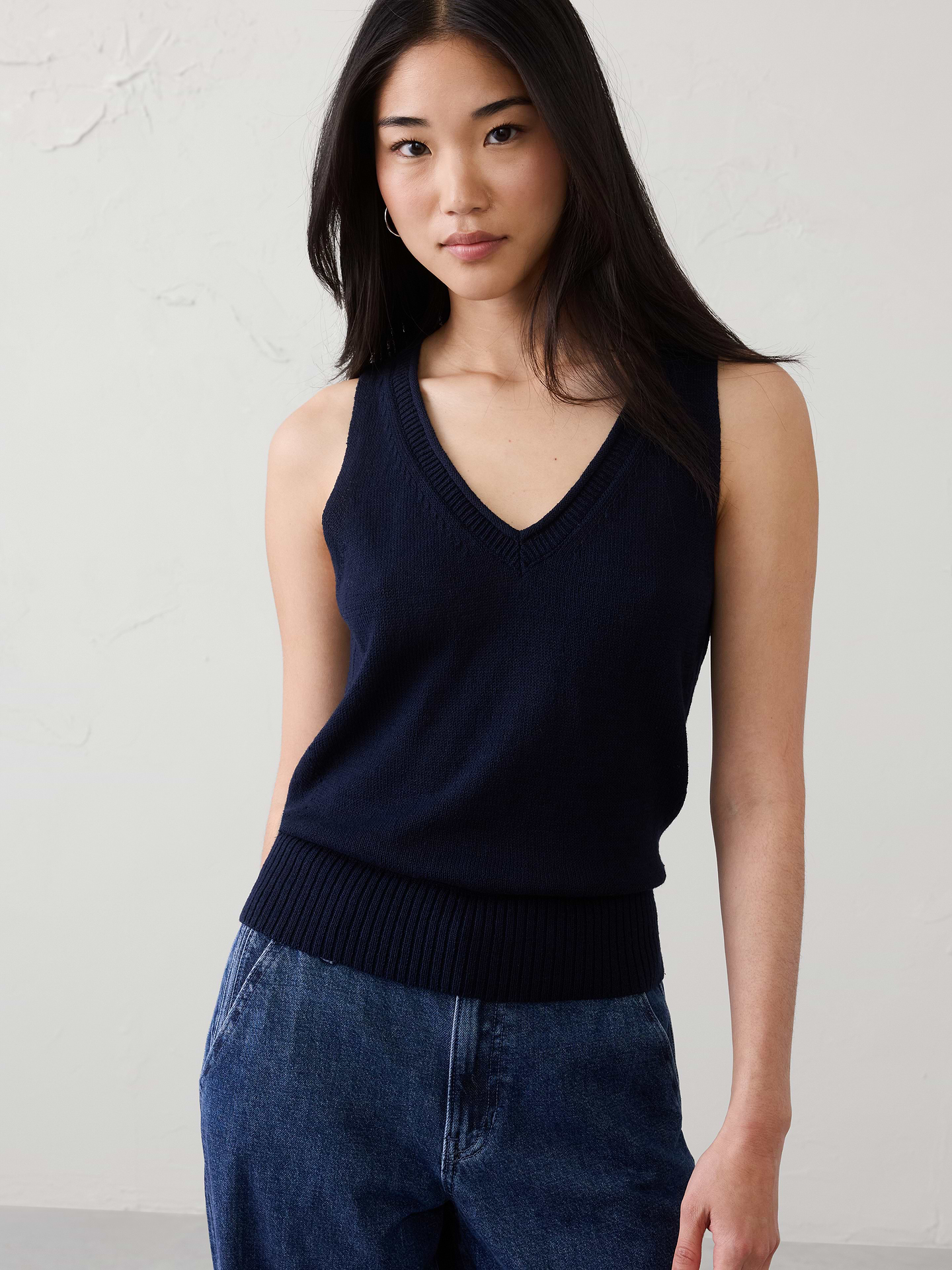 Image 1 of 4, Crafted from a beautifully breathable yarn, this sweater tank feels soft and airy against the skin—light enough for warmer days yet still holding a softly tailored silhouette. Ramie’s natural texture lends a cool, lightweight hand feel with a subtly lustrous finish, giving the garment an effortless sense of ease and refined simplicity., V-neck. Sleeveless., Ribbed neck, arm cuffs and hem., Features a delicate pointelle‑stitch detail along the sides, adding subtle texture and a refined, decorative touch to the silhouette., Straight hem., Made exclusively for Banana Republic Factory., Product #1174853