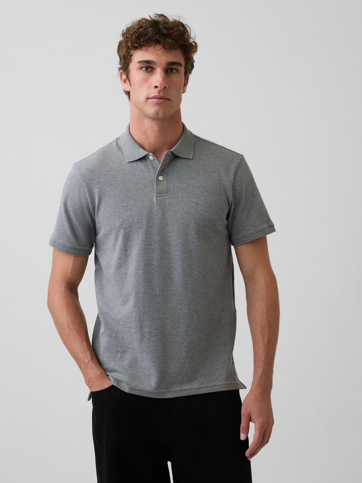 Image 1 of 3, Soft, stretch pique knit with moisture-wicking properties., Short sleeves with flat rib-knit cuffs., Flat rib-knit polo collar., Button placket., Side vents at hem., This product was made in a factory that invests in gender equity and women’s empowerment through RISE. Learn more at gapinc.com/equity ., Product #223627
