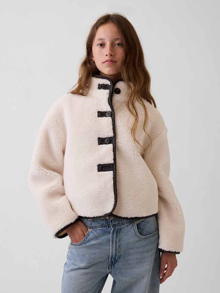 Image 1 of 6, Soft sherpa jacket with vegan leather trim. In a relaxed fit and cropped length., Mockneck., Long sleeves with drop shoulders., Button front., Vegan leather trim at button hole patches and binding., Made with 30% recycled polyester. Compared to virgin materials, using recycled materials helps reduce resource use and waste., Product #1179995