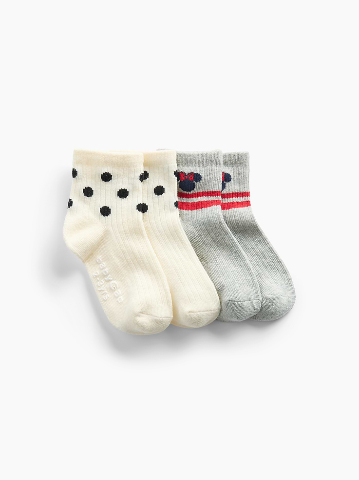 Image 1 of 1, Gap and Disney. Two timeless American brands. One collection that celebrates Mickey Mouse and Minnie Mouse., Soft stretch knit crew socks., Ribbed top., Reinforced toe and heel., Disney's Minnie Mouse graphic with double stripes at top or polka dot print., Made with 10% recycled polyester. Compared to virgin materials, using recycled materials helps reduce resource use and waste., Product #913641