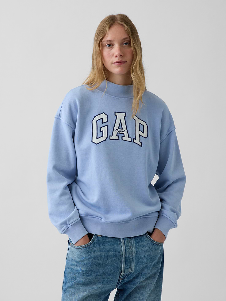 Image 1 of 7, Soft cotton-blend fleece pullover sweatshirt. In an oversized fit and tunic length., Mockneck., Long sleeves with drop shoulders., Gap arch logo at front., Banded rib cuffs and hem., Made with 52% Protocol cotton verified by the U.S. Cotton Trust Protocol, a program which works with farms committed to improving their environmental footprint by minimizing water usage and improving soil health (Claim No. 10127)., Made with 23% recycled polyester. Compared to virgin materials, using recycled materials helps reduce resource use and waste., Product #908994
