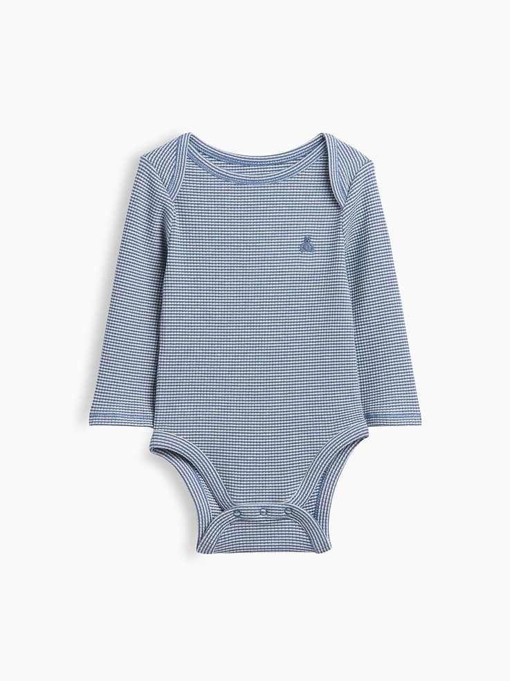Image 1 de 3, De la première tenue de bébé à tous ses premiers instants. Nos essentiels préférés sont maintenant offerts dans une texture côtelée ultra-fine d’une douceur incomparable. Avec une extensibilité accrue pour les petites poussées de croissance de votre enfant., Ras du cou. Certains modèles ont une patte de boutonnage sur le devant ou des épaules chevauchées pour faciliter le passage de la tête., Manches longues., Ourson Brannan brodé sur la poitrine., Certains modèles ont une poche appliquée sur le devant., Boutons-pression à l’entrejambe pour habiller et changer bébé facilement., Fait de polyester recyclé à 38 %. Comparativement aux matières vierges, l’utilisation de matières recyclées permet de réduire l’utilisation des ressources et le gaspillage., Ce produit a été fabriqué dans une usine qui investit dans l’égalité des genres et l’autonomisation des femmes grâce au programme Reimagining Industry to Support Equality (RISE). Pour en savoir plus, visitez gapinc.com/equite ., Produit #783317