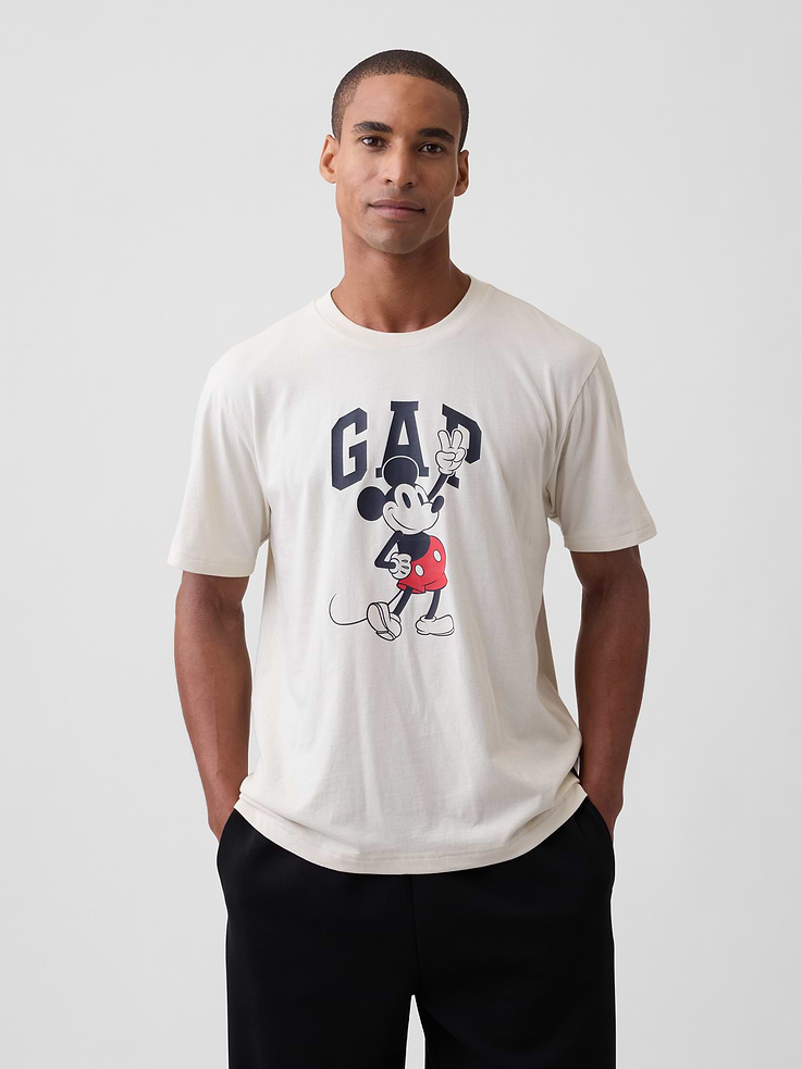 Image 1 of 5, A very special collaboration between Gap and Disney— two timeless, iconic American brands— led us to create a collection that celebrates Mickey Mouse and Minnie Mouse., Soft jersey knit., Dropped shoulder, short sleeves., Crewneck., Gap logo with graphic at front., Product #1180048
