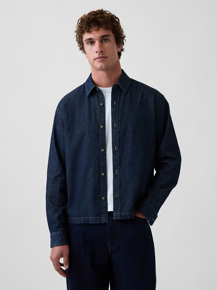Image 1 of 5, Authentic, non-stretch denim button-up shirt. In a relaxed, boxy fit., Point collar, button front., Long sleeves with drop shoulders and button cuffs., Straight hem., Dark rinse., Responsibly Made: This denim shirt is part of our water-saving Washwell program. Compared with conventional wash methods, Washwell uses at least 20% less water., More Sustainable Cotton: Made with 5% recycled cotton. Compared to virgin materials, using recycled materials helps reduce resource use and waste., This product was made in a factory that invests in gender equity and women’s empowerment through RISE. Learn more at gapinc.com/equity ., Product #1185320