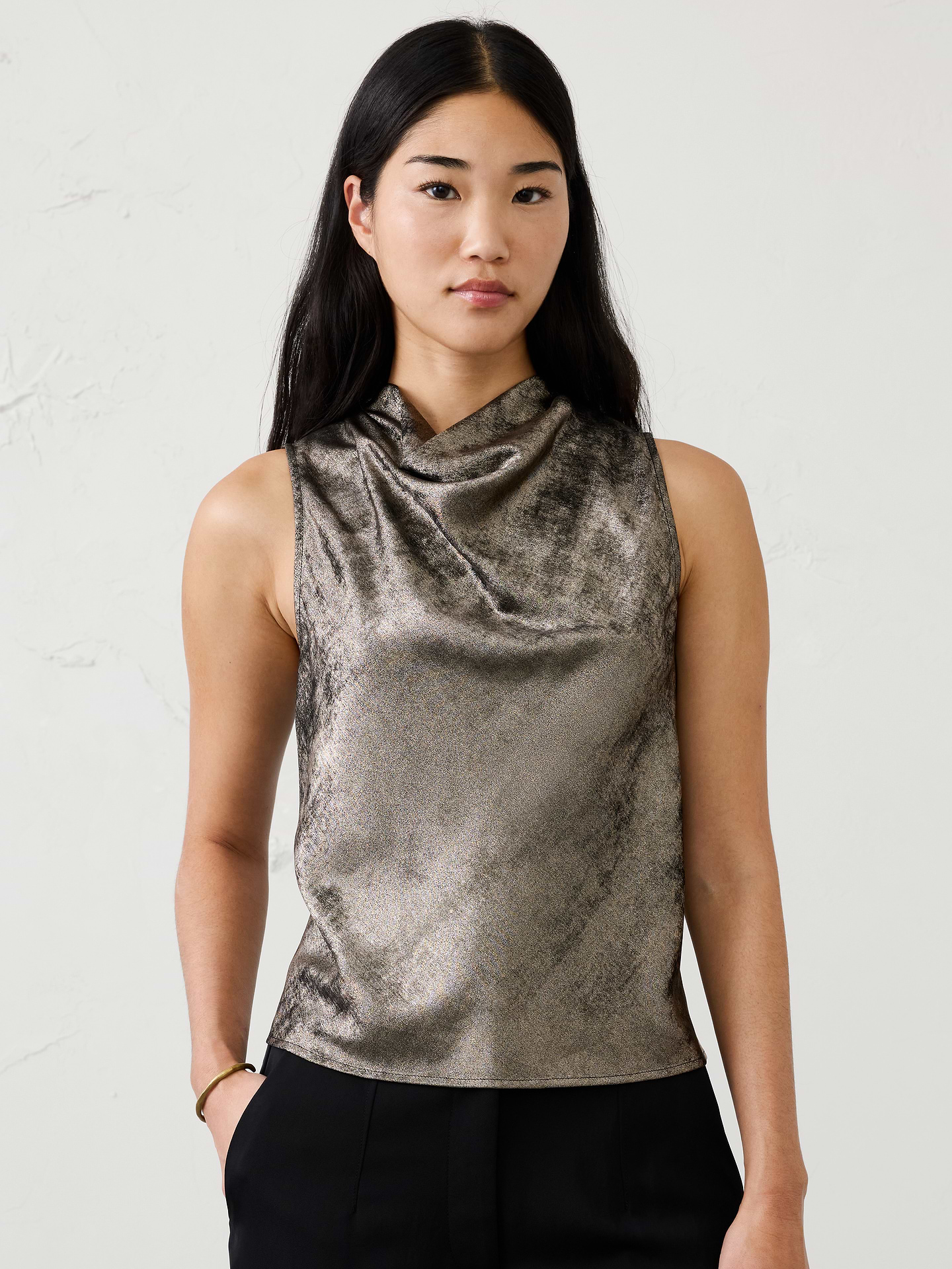 Image 1 of 4, Crafted in our refined metallic lamé fabrication, this elevated top features a graceful cowl neckline for an effortlessly sophisticated look. The subtle shimmer makes it a standout choice for holiday gatherings, evenings out, and special occasions., Soft cowl high neckline. Sleeveless., Back keyhole opening with two-button closure., Lamé fabric gives a special eye-catching sheen, making it ideal for holiday events., Made exclusively for Banana Republic Factory., Product #1185910