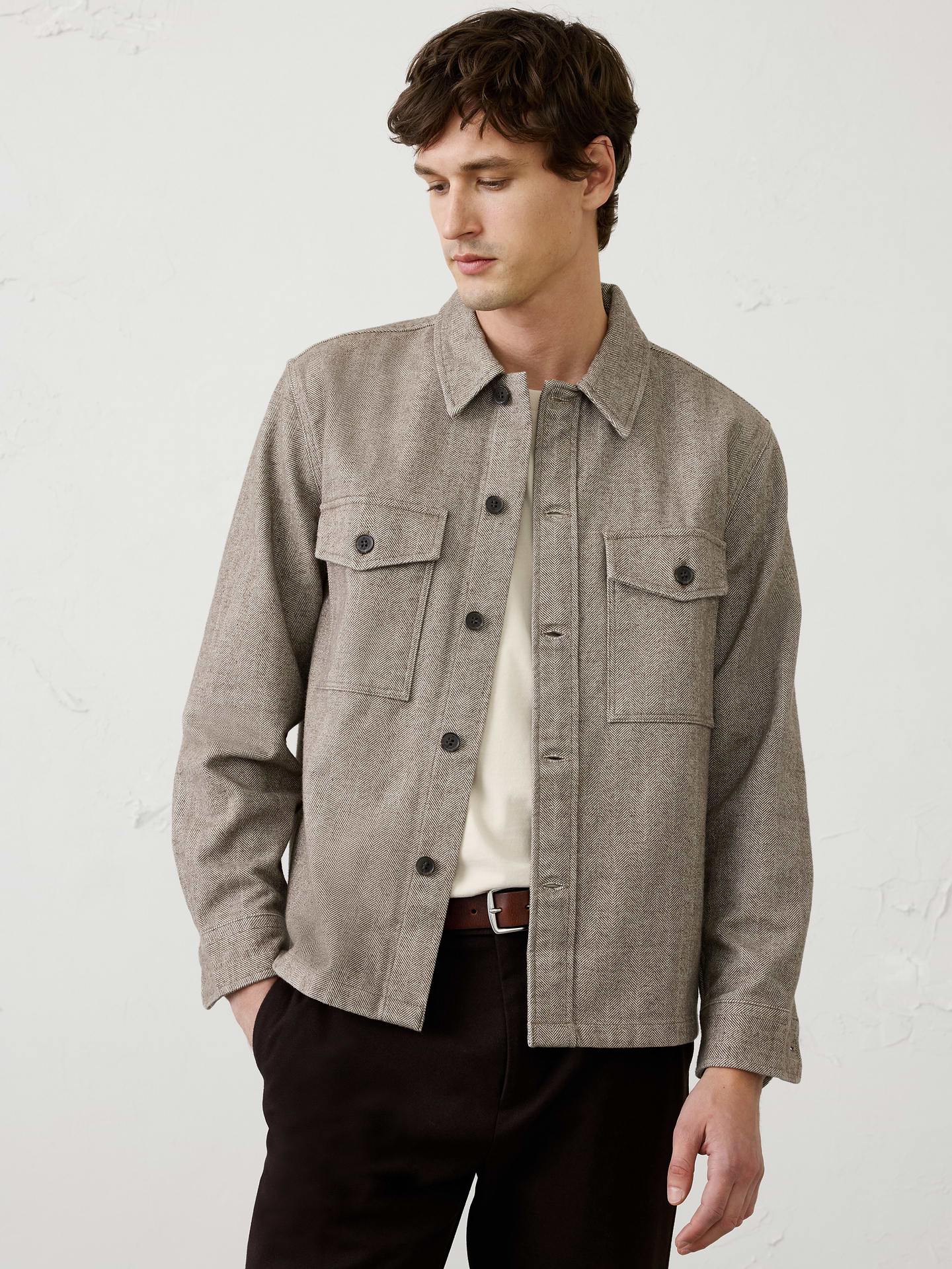 Image 1 of 3, A customer favorite returns in an easy, relaxed silhouette, crafted with heritage‑inspired herringbone texture for timeless appeal. The versatile weight makes it an ideal layering piece, offering a polished alternative to heavier jackets as temperatures begin to cool., Point collar. Long sleeves with adjustable button cuffs., Button front closure., Dual chest patch pockets with flap buttoned closure., Back yoke seam., Straight hem with side seam slits., Made exclusively for Banana Republic Factory., Product #1179775