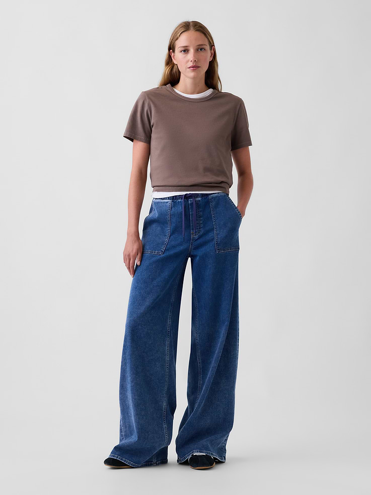 Image 1 of 6, Fit: A full-length, knit denim baggy jean that's fitted on the waist & relaxed all the way down., Fabric: 79% Cotton, 20% Recycled Materials, 1% Stretch., Stretch: Low Stretch Jeans. Authentic denim with a soft & easy lived-in feel.​, Rise: Mid Rise Jeans., Look: A pull-on knit denim baggy jean in a medium wash. ​, Details: Elasticized waist with drawcords, faux fly, front & back patch pockets., Responsibly Made: This pair of jeans is part of our water-saving Washwell program. Compared with conventional wash methods, Washwell uses at least 20% less water., More Sustainable Materials: Made with 15% recycled polyester and 5% recycled cotton. Compared to virgin materials, using recycled materials helps reduce resource use and waste., This product was made in a factory that invests in gender equity and women’s empowerment through RISE. Learn more at gapinc.com/equity ., Product #1185288