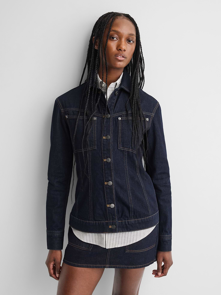 Image 1 of 9, Authentic, rigid denim jacket. In a slim, structured fit., Spread collar., Long sleeves with logo button cuffs., Logo button-front and rivet hardware detailing., Slanted patch pockets at chest., Gap × A.P.C. logo leather patch at rear hem., More Sustainable Cotton: Made with 100% regeneratively grown cotton which is grown using holistic agricultural practices that aim to improve soil health and water retention., Responsibly Made: This jacket is part of our water-saving Washwell program. Compared with conventional wash methods, Washwell uses at least 20% less water., Product #1179759