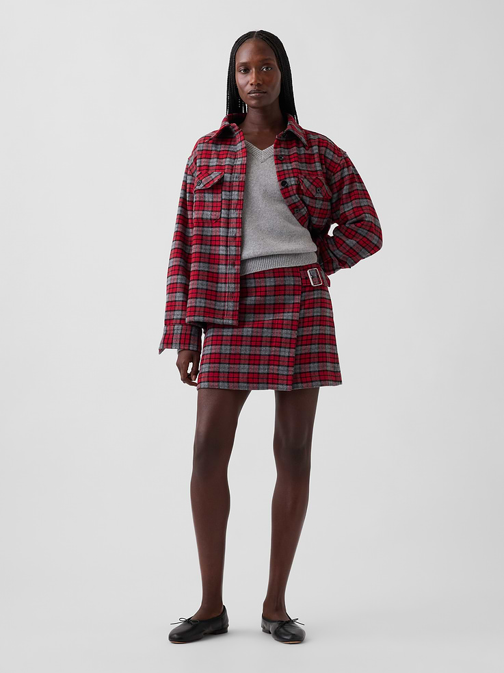Image 1 of 6, Soft wool-blend twill wrap skort. In an ultra mini length., Faux wrap waist with belt buckle closure., Concealed zipper with hook-and-eye closure at side seam., Back waist darts., Allover plaid., Attached inner shorts., Skirt made with 69% recycled polyester. Compared to virgin materials, using recycled materials helps reduce resource use and waste., This product was made in a factory that invests in gender equity and women’s empowerment through RISE. Learn more at gapinc.com/equity ., Product #1184535