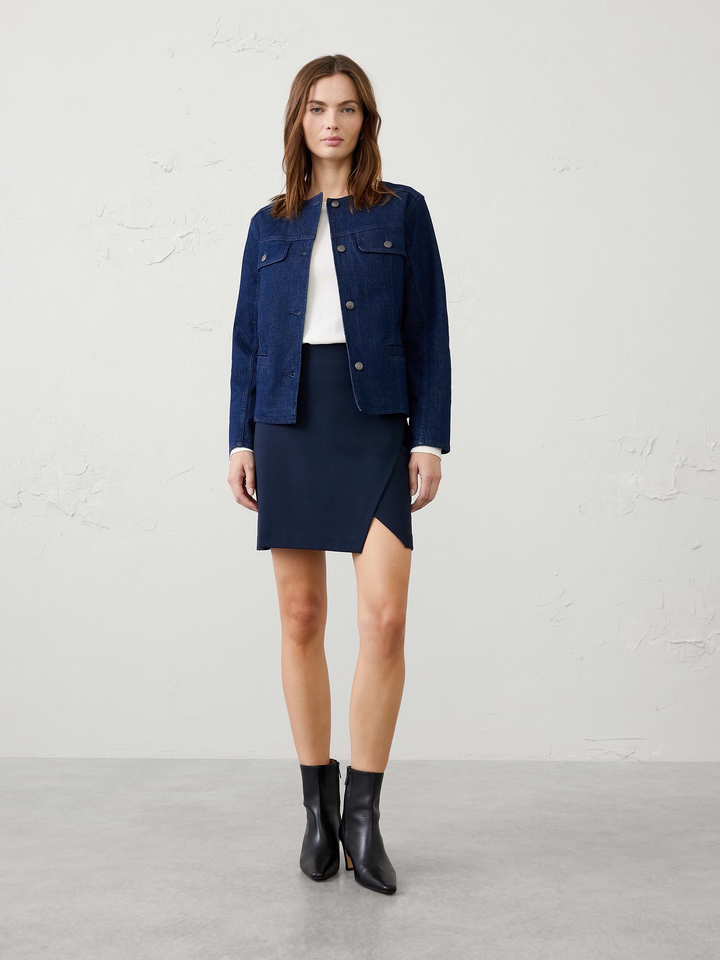 Image 1 of 8, Crafted from our suiting ponte fabrication, this mini skirt combines a polished look with comfortable stretch for all‑day wear. A subtle overlap detail at the front adds a modern touch., Clean waistband., Concealed side‑zip closure., Angled wrap-front with front slit detail., Invisible side zipper closure., Back waist darts., Straight hem., Fully lined., Made exclusively for Banana Republic Factory., Product #1178076