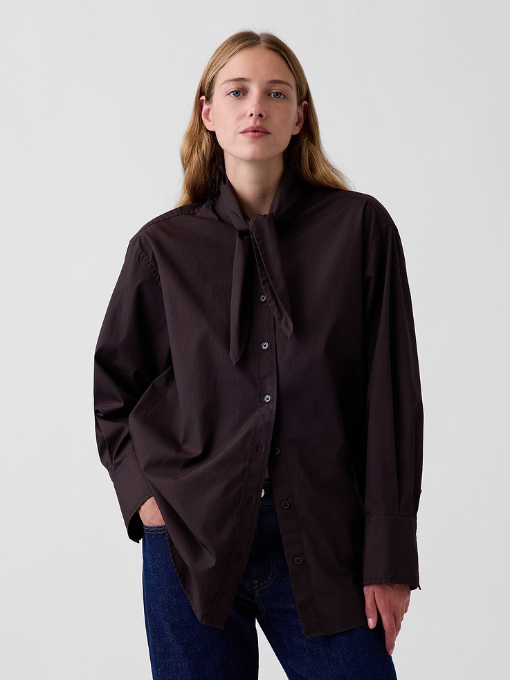 Image 1 of 5, Our oversized shirt pulled straight from the archives. Always easy. Forever iconic., Organic cotton poplin button-up shirt. In an oversized fit and longer length., Tie neck, button front., Long sleeves with button cuffs., Back yoke seam., Shirttail hem., Made with 100% organically grown cotton which is grown without the use of synthetic pesticides and fertilizers., This product was made in a factory that invests in gender equity and women’s empowerment through RISE. Learn more at gapinc.com/equity ., Product #1184843