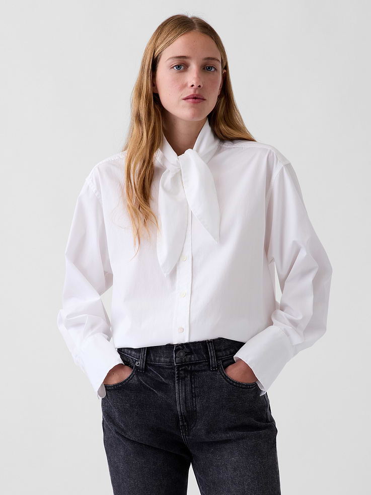 Image 1 of 5, Our oversized shirt pulled straight from the archives. Always easy. Forever iconic., Organic cotton poplin button-up shirt. In an oversized fit and longer length., Tie neck, button front., Long sleeves with button cuffs., Back yoke seam., Shirttail hem., Made with 100% organically grown cotton which is grown without the use of synthetic pesticides and fertilizers., This product was made in a factory that invests in gender equity and women’s empowerment through RISE. Learn more at gapinc.com/equity ., Product #1184843