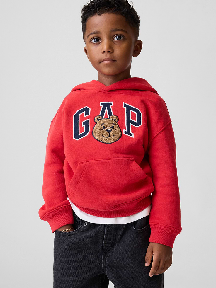 Image 1 of 4, Our softer than soft sweats. Brushed on the inside. Smooth on the outside. Made so that no two are alike., Soft cotton-blend fleece pullover hoodie., Hooded neckline, Long sleeves with drop shoulders, Gap logo with textured Brannan Bear graphic at front., Kanga pocket., Banded rib cuffs and hem., Made with 52% Protocol cotton verified by the U.S. Cotton Trust Protocol, a program which works with farms committed to improving their environmental footprint by minimizing water usage and improving soil health (Claim No. 10127)., Made with 23% recycled polyester. Compared to virgin materials, using recycled materials helps reduce resource use and waste., This product was made in a factory that invests in gender equity and women’s empowerment through RISE. Learn more at gapinc.com/equity ., Product #1185363