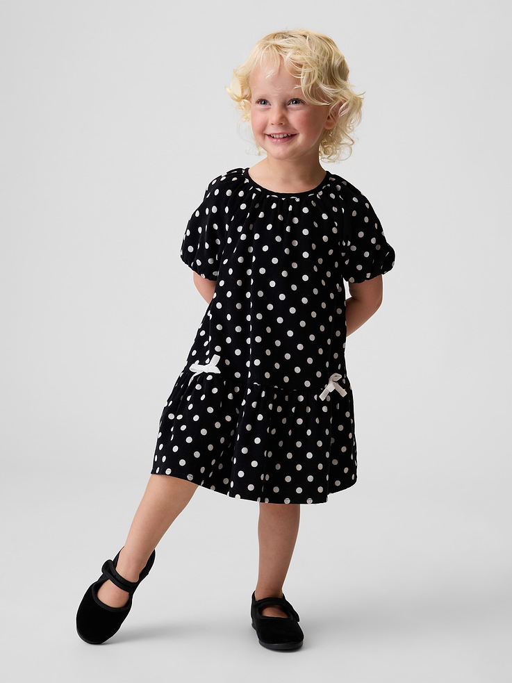 Image 1 of 3, Soft cotton corduroy dress., Round neck with loop button keyhole closure at back., Short raglan sleeves with elasticized cuffs., Tacked bows at front., Shirring at waist seam., Allover polka dot print., Product #912226