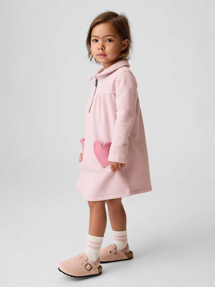 Image 1 de 3, Molleton en mélange de coton doux., Col Claudine avec patte de boutonnage à glissière à l’avant., Manches longues., Fronces à la taille empire cousue., Poches appliquées en forme de cœur à l’avant., Fait de polyester recyclé à 21 %. Comparativement aux matières vierges, l’utilisation de matières recyclées permet de réduire l’utilisation des ressources et le gaspillage., Produit #912138