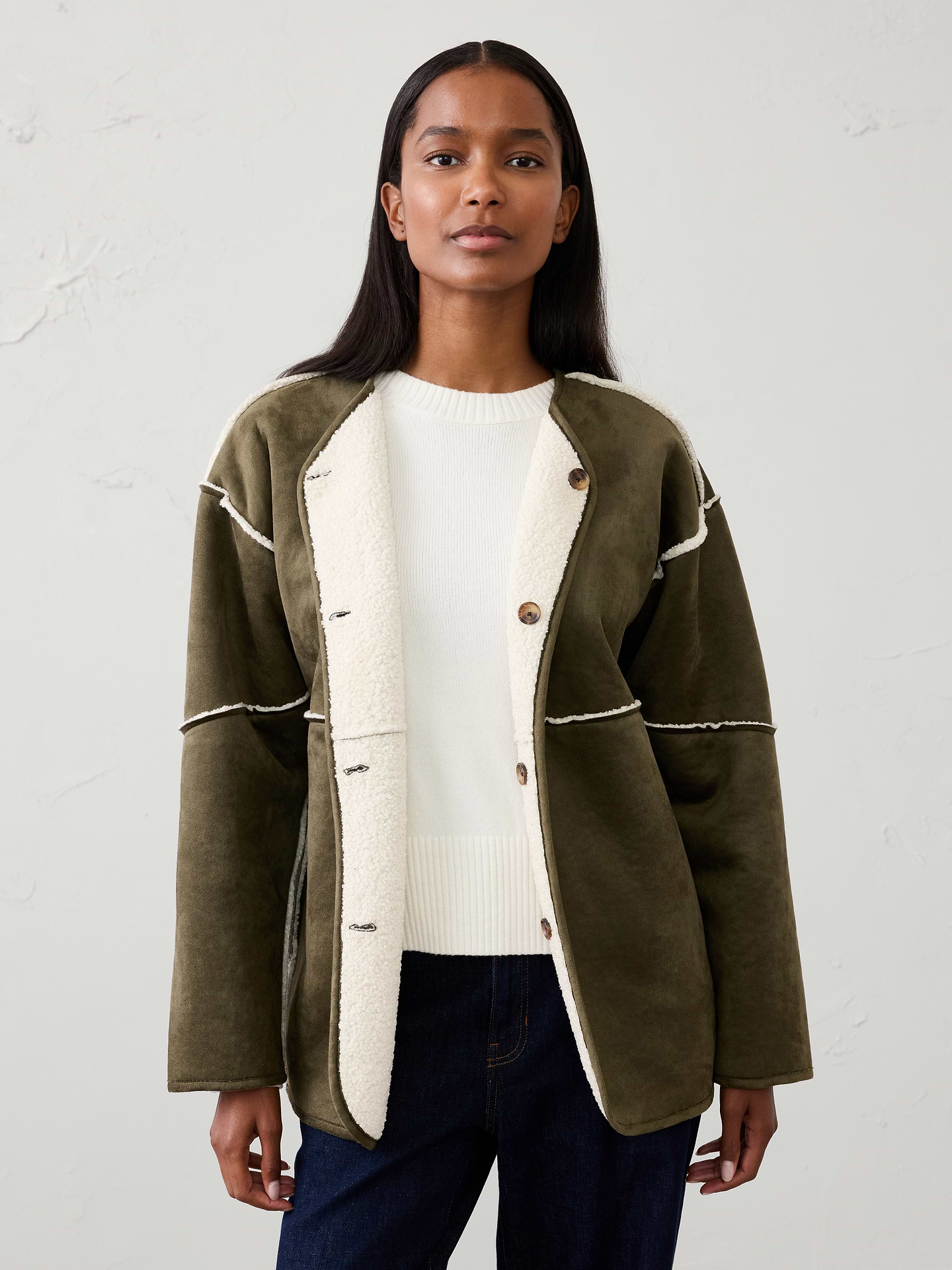 Image 1 of 4, We updated our best-seller with a crew neckline. This jacket is fully reversible: one side with cozy sherpa and the other with soft luxe vegan suede., VEGAN SUEDE: Soft and smooth, this faux leather looks and feels luxurious., Collarless neck. Long sleeves., Drop shoulders., Button front closure., On-seam side pockets., Front and back center seam., Straight hem., Made exclusively for Banana Republic Factory., Product #812005