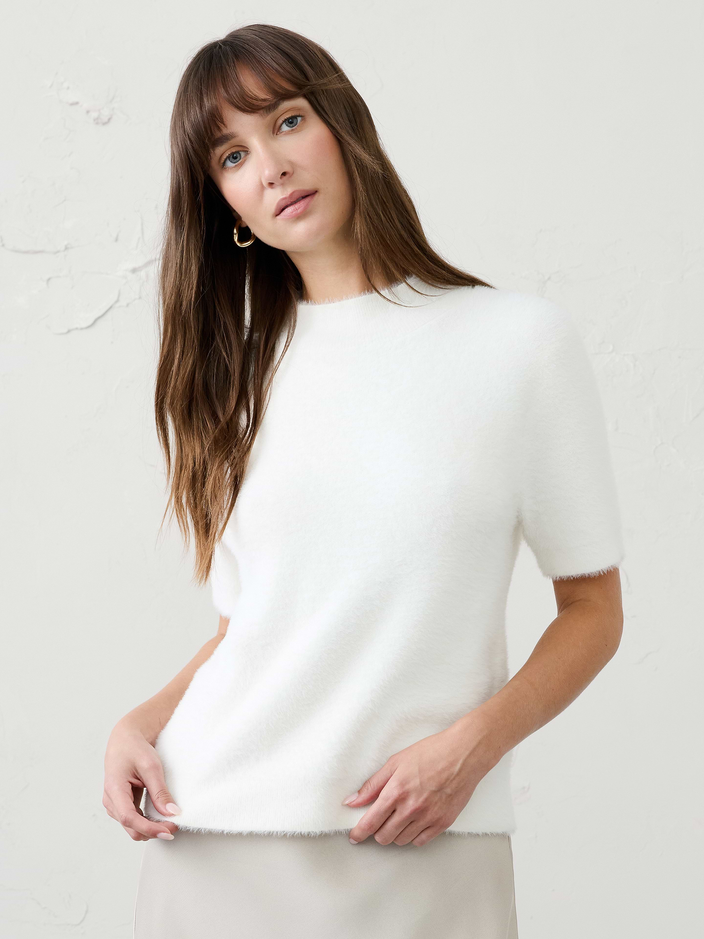Image 1 of 4, Crafted from our signature eyelash yarn, this mockneck sweater delivers a plush, luxurious feel with rich texture and cozy warmth. The elevated mockneck silhouette adds a refined touch, while the soft, fuzzy finish makes it a standout piece for cooler weather., Mock neck. Short sleeves., Ribbed neck, arm cuffs and hem., Care suggestion: Use a low‑heat iron; steam as needed., Made exclusively for Banana Republic Factory., Product #1177067