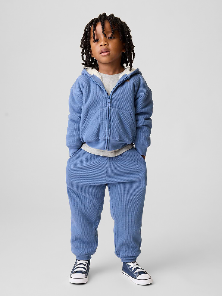 Image 1 of 4, Soft waffle-knit cotton joggers with a cozy sherpa lining., Elasticized rib waist with drawcords., Side on-seam pockets., Elasticized cuffs., Sherpa lining made with 100% recycled polyester. Compared to virgin materials, using recycled materials helps reduce resource use and waste., This product was made in a factory that invests in gender equity and women’s empowerment through RISE. Learn more at gapinc.com/equity ., Product #1184878