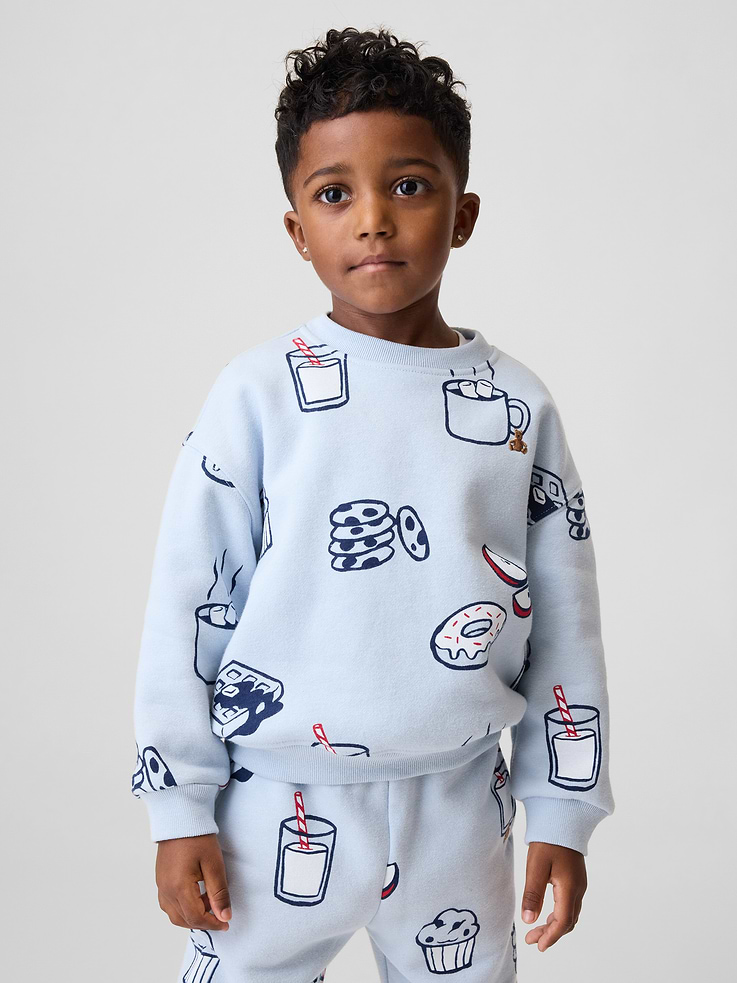 Image 1 of 4, Our softer than soft sweats. Brushed on the inside. Smooth on the outside. Made so that no two are alike., Soft cotton-blend fleece sweatshirt., Crewneck., Long sleeves with banded cuffs., Embroidered Brannan Bear at chest., Allover football graphics., Banded hem., Made with 23% recycled polyester. Compared to virgin materials, using recycled materials helps reduce resource use and waste., This product was made in a factory that invests in gender equity and women’s empowerment through RISE. Learn more at gapinc.com/equity ., Product #830674