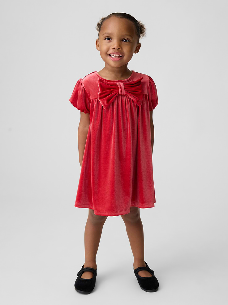 Image 1 of 4, Soft, stretch velour knit dress., Round neck with back button placket., Lawn-lined puff sleeves with elasticized openings., Bow detail at front., This product was made in a factory that invests in gender equity and women’s empowerment through RISE. Learn more at gapinc.com/equity ., Product #1185566