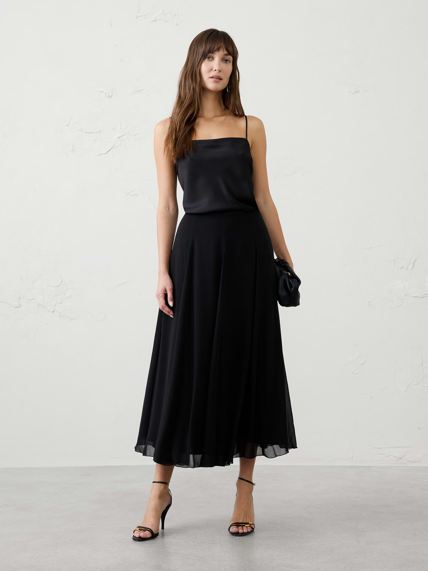 Image 1 of 4, Float through your day in effortless style with this swing pleated midi skirt. Designed with a graceful A-line silhouette, this elegant skirt features soft pleats that create beautiful movement and flow with every step. The midi length offers timeless versatility, while the lightweight fabric drapes beautifully for a flattering, feminine look. Perfect for dressing up with heels or styling casually with flats and knitwear, this skirt transitions seamlessly from workdays to special occasions., Smooth waistband for a clean, polished finish., Soft pleating adds dimension and graceful drape., Side zip closure., Elegant swing silhouette with fluid movement., Fully lined., Made exclusively for Banana Republic Factory., Product #1185764